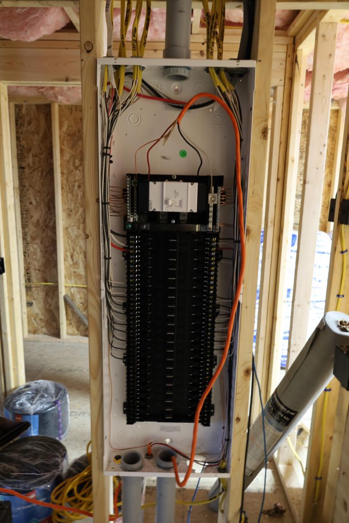 modular home wiring/electrical, black rectangular shaped box, with an orange cord holding three cables dangling down into a hollow tube