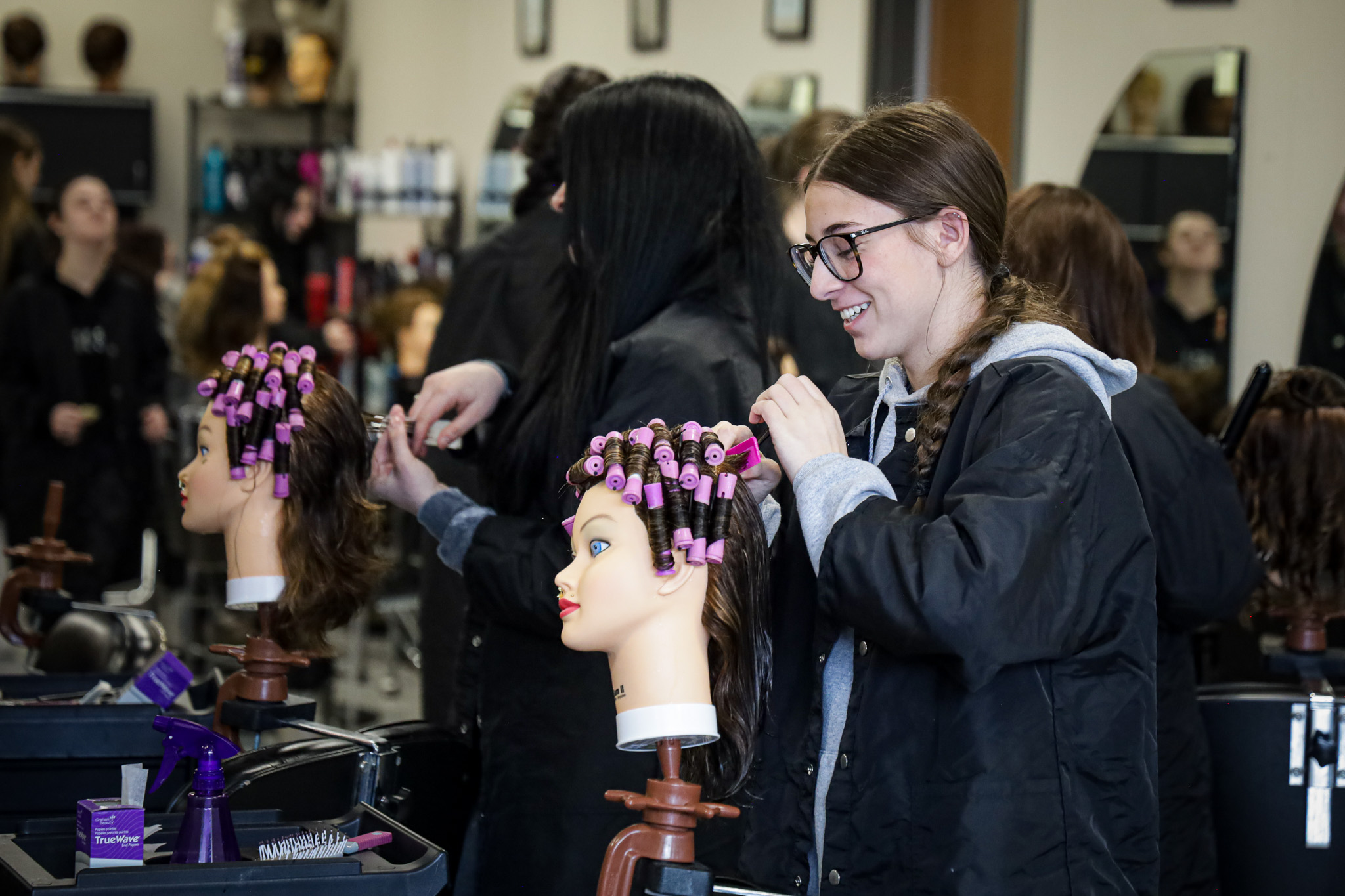 cosmetology students combing mannequin heads