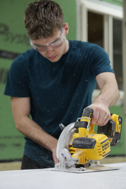 student using buzzsaw on dry wall