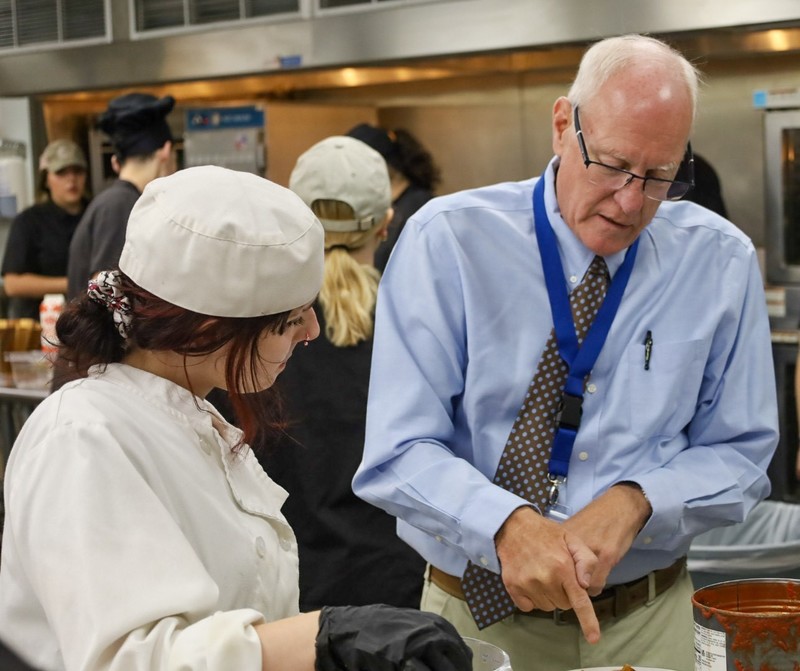 Man discussing with student on food
