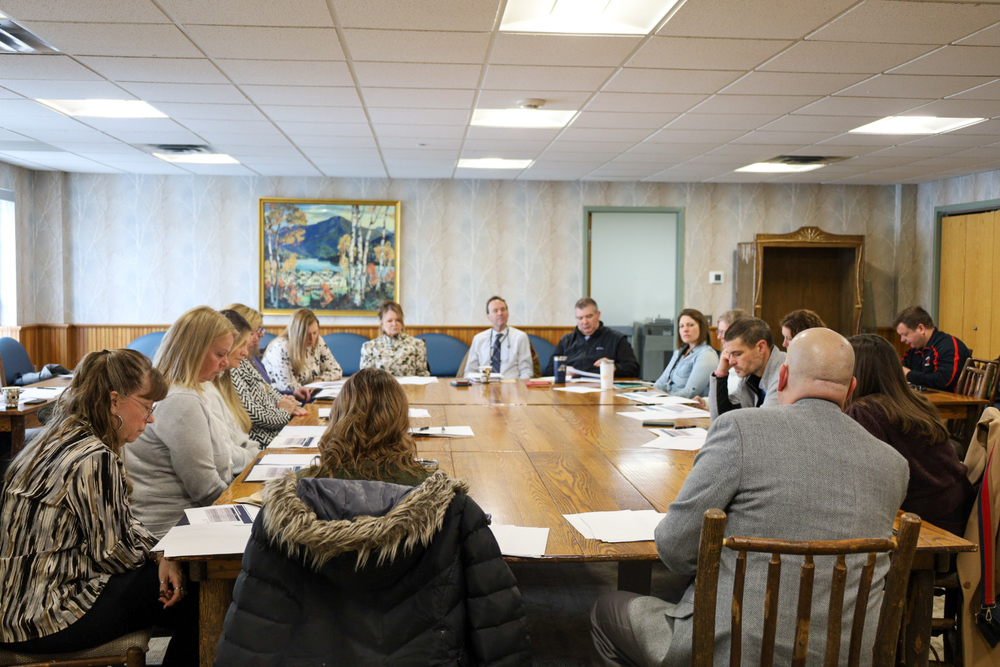group of people sat at a table discussing.