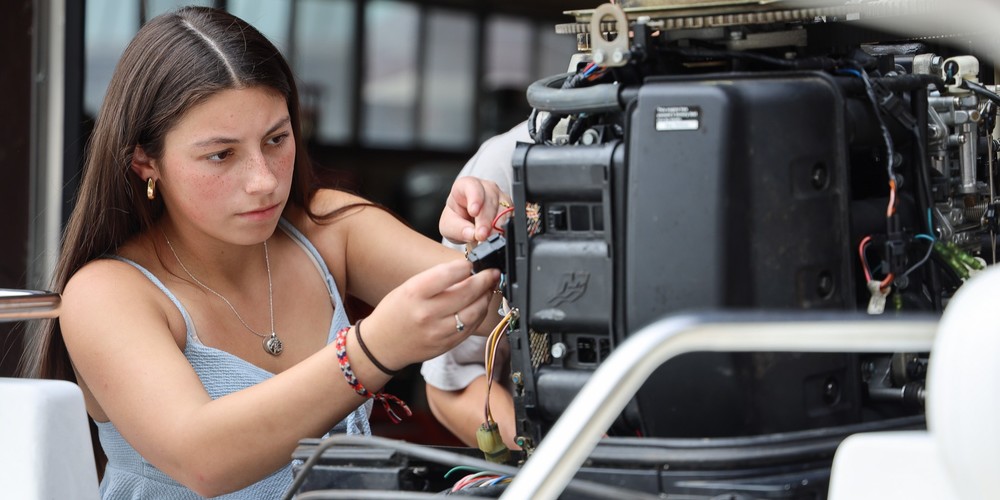 Girl working on wires on a machine