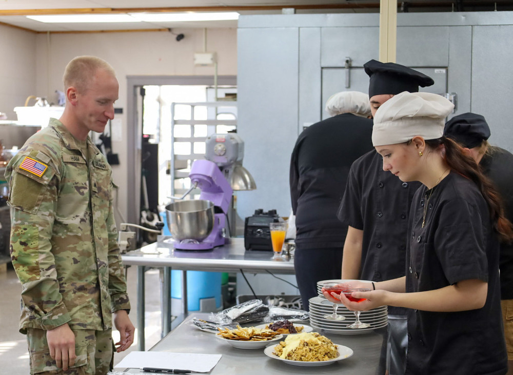 students handing food to national guard member