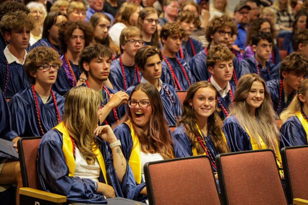 Graduates sitting in auditorium seats during ceremony