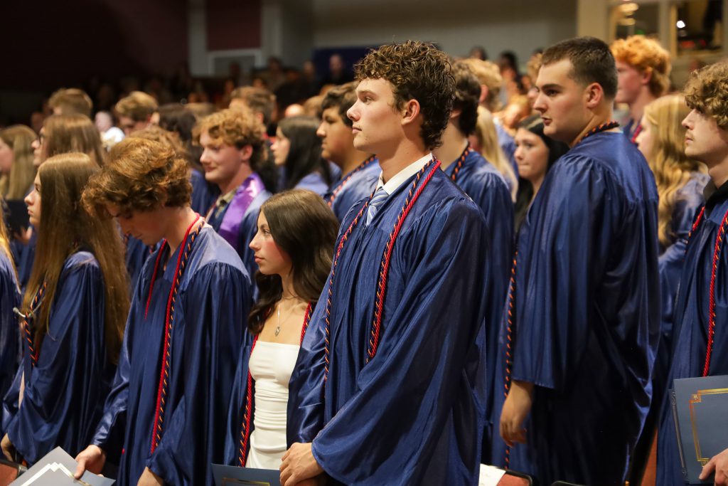Graduates standing at the end of the ceremony