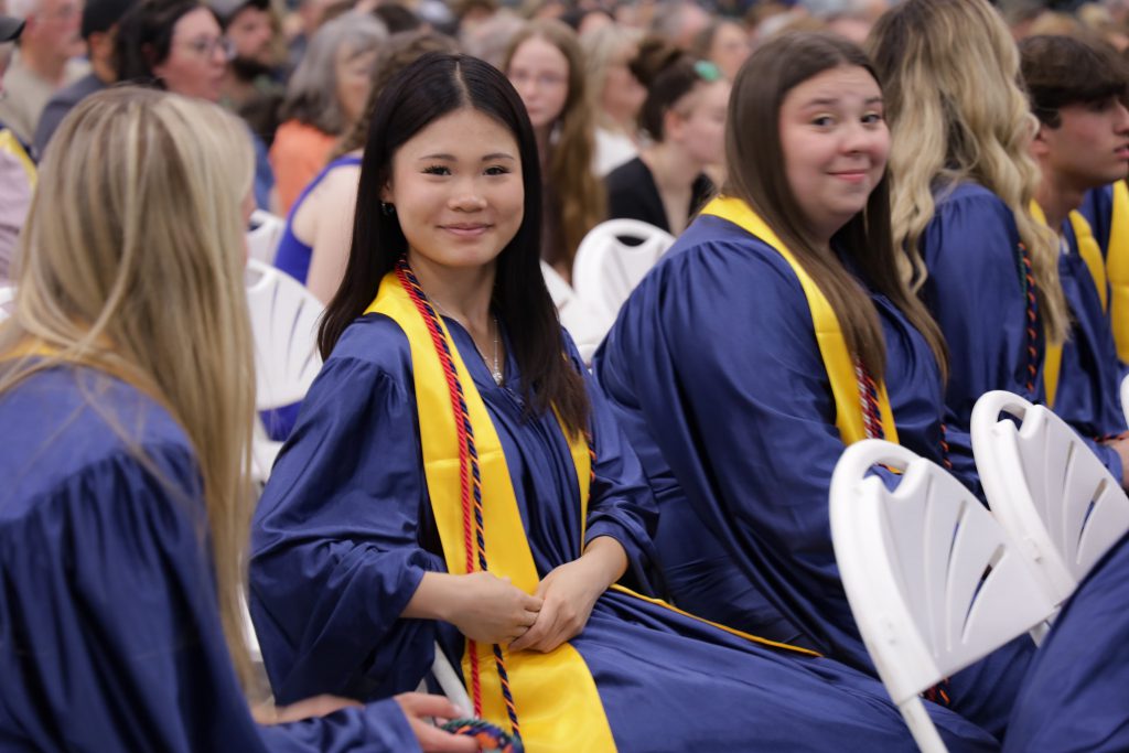 Graduate smiles at camera during ceremony