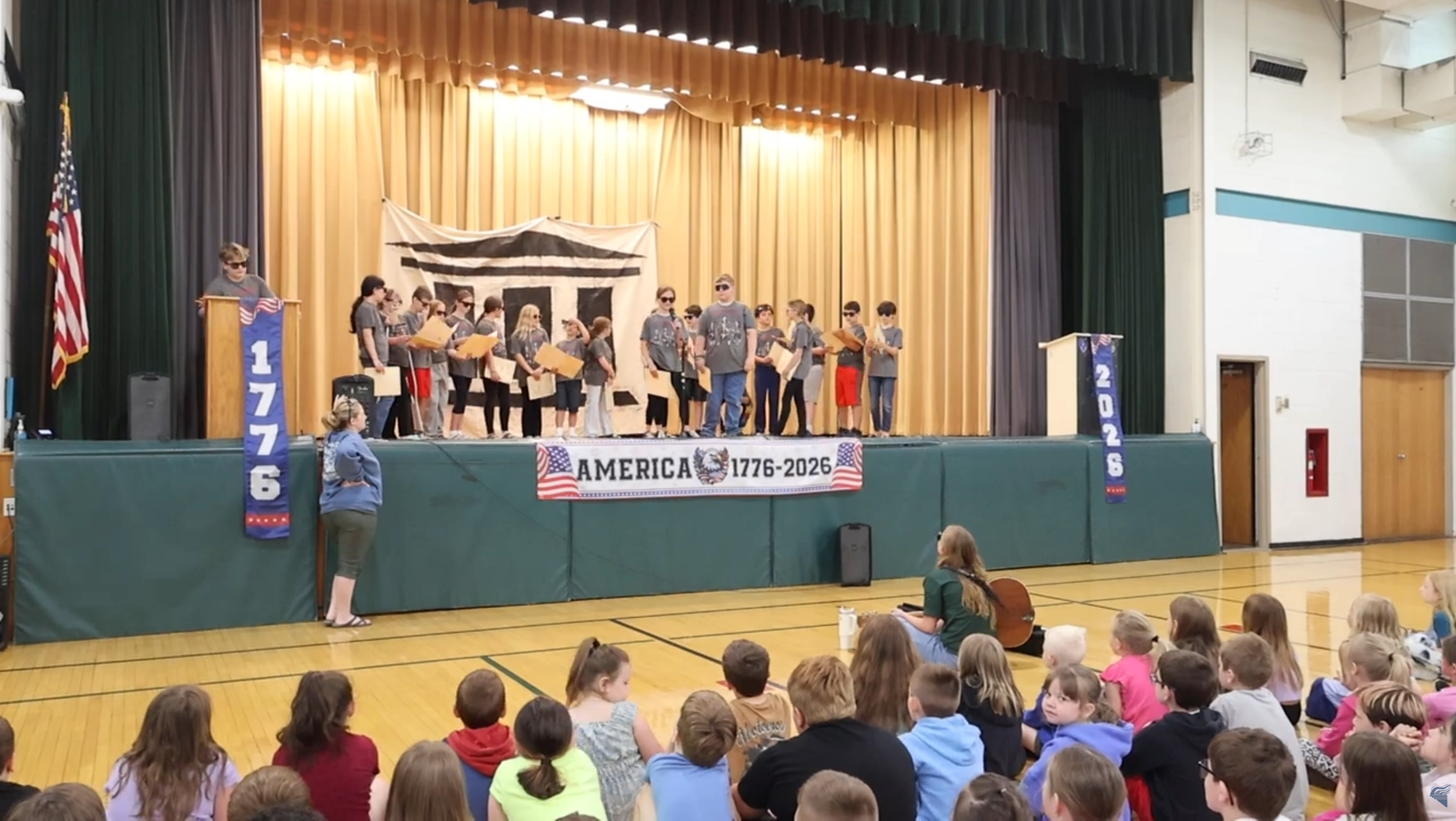 Students on stage performing play.