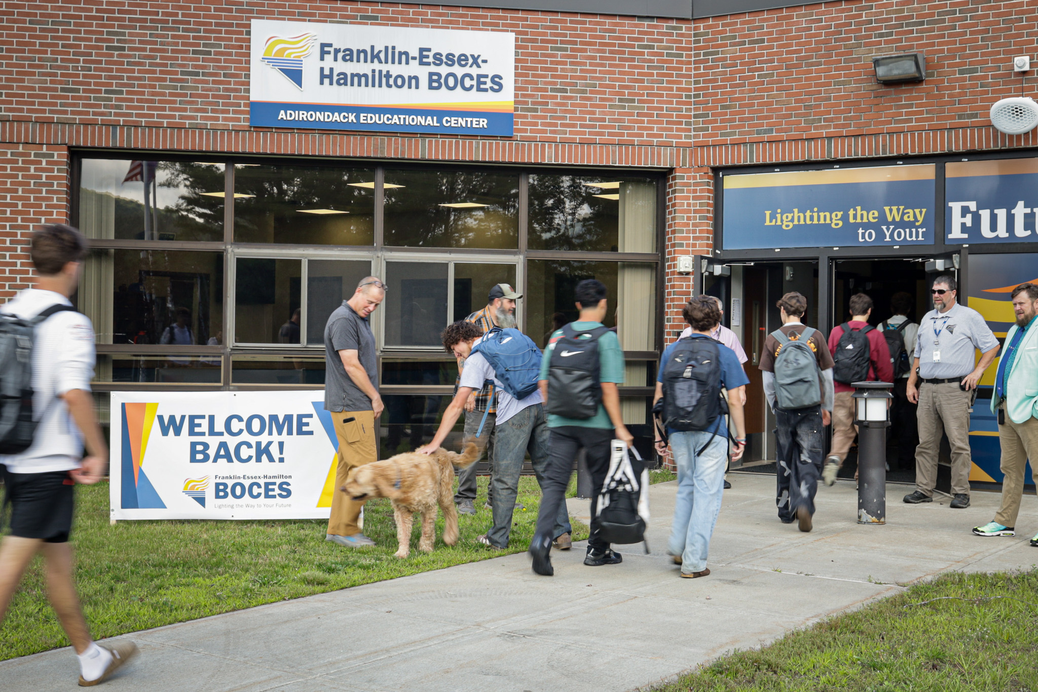 students entering adirondack educational center with staff welcoming them at the door