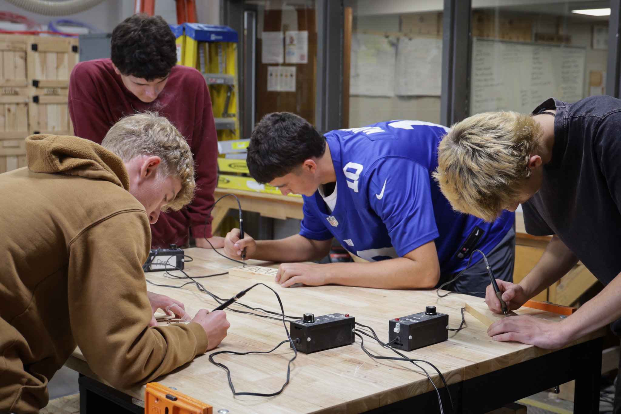 building trade students buring names onto pieces of wood